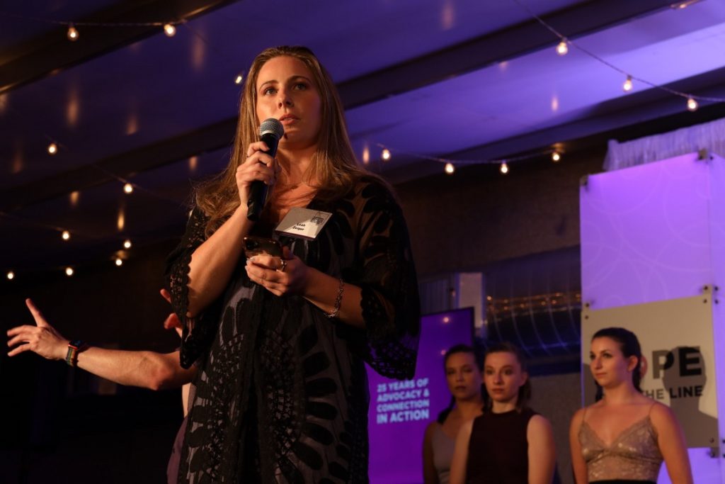 Leah Zeiger speaking to audience before performance performance for the National Hotline for Domestic Violence; courtesy of the Hotline.